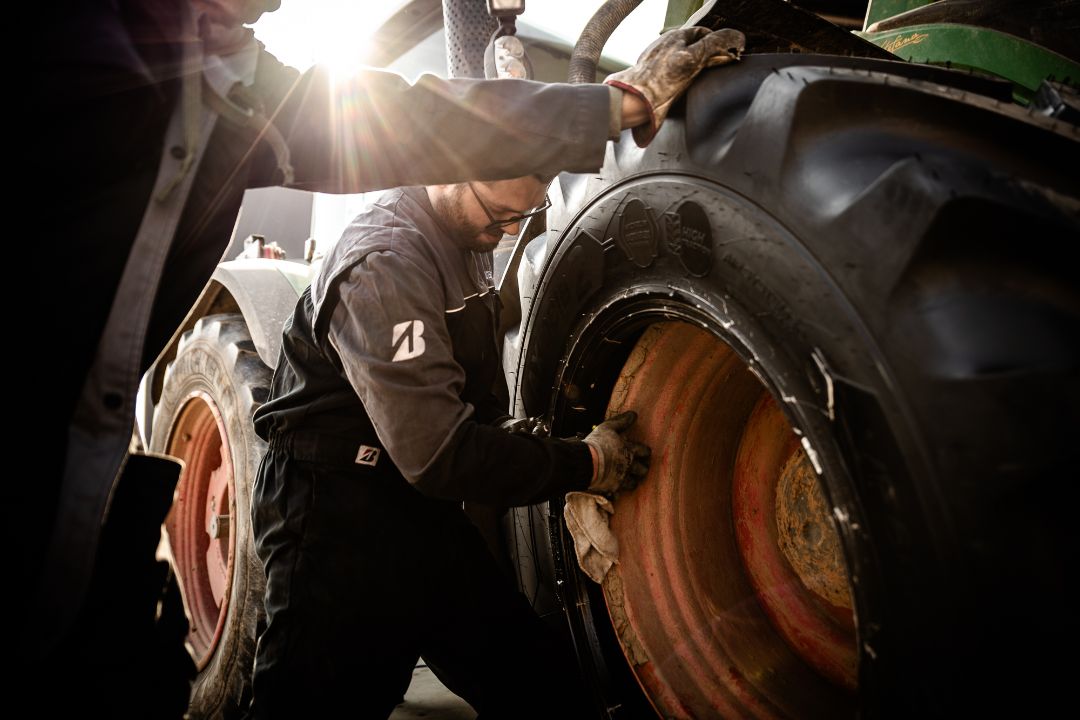 Tecnico Ermes Gomme monta pneumatico agricolo trattore Fendt in controluce officina Poirino