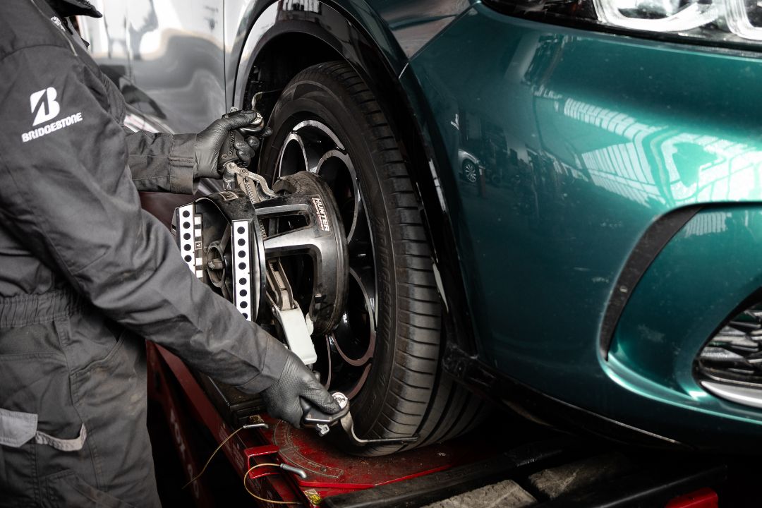 Tecnico Ermes Gomme aggancia sensore Hunter sulla ruota di una MINI per convergenza 3D